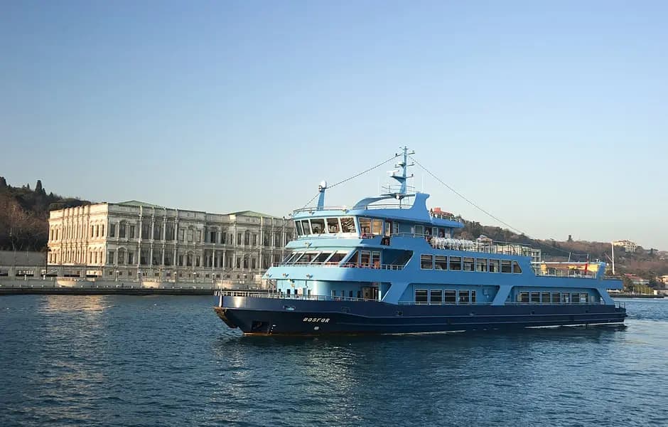 The BOSFOR sailing past a grand waterside building on the European shore in daylight