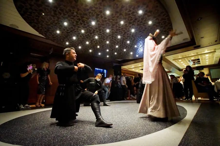 Two performers dancing together on the dance floor, one in black and one in a flowing pink and white costume